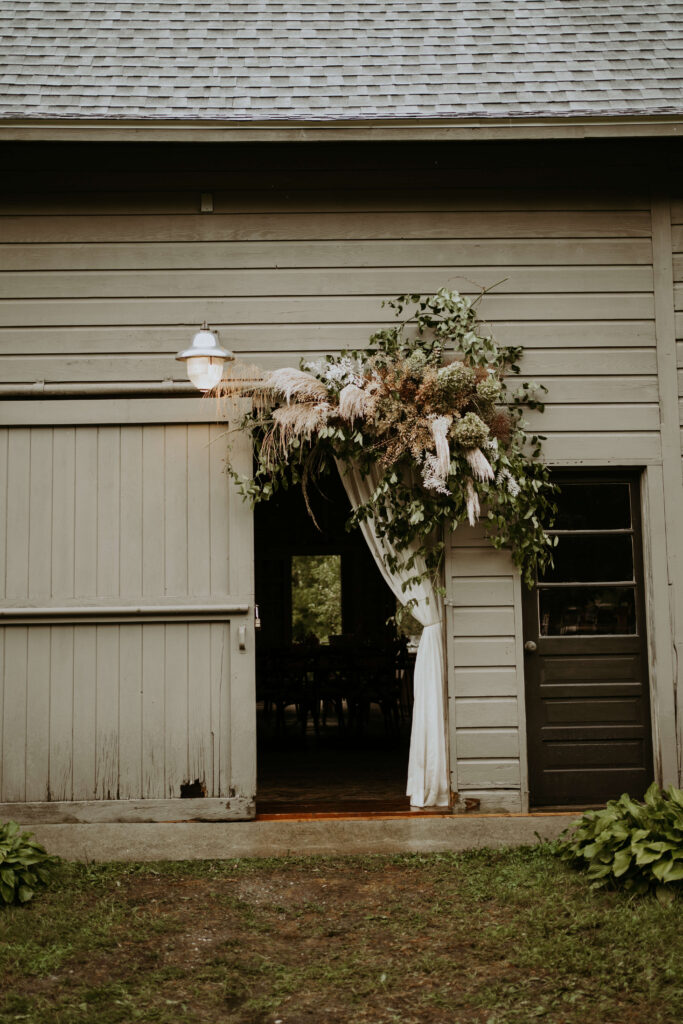 Barn entryway decorated with floral arrangements